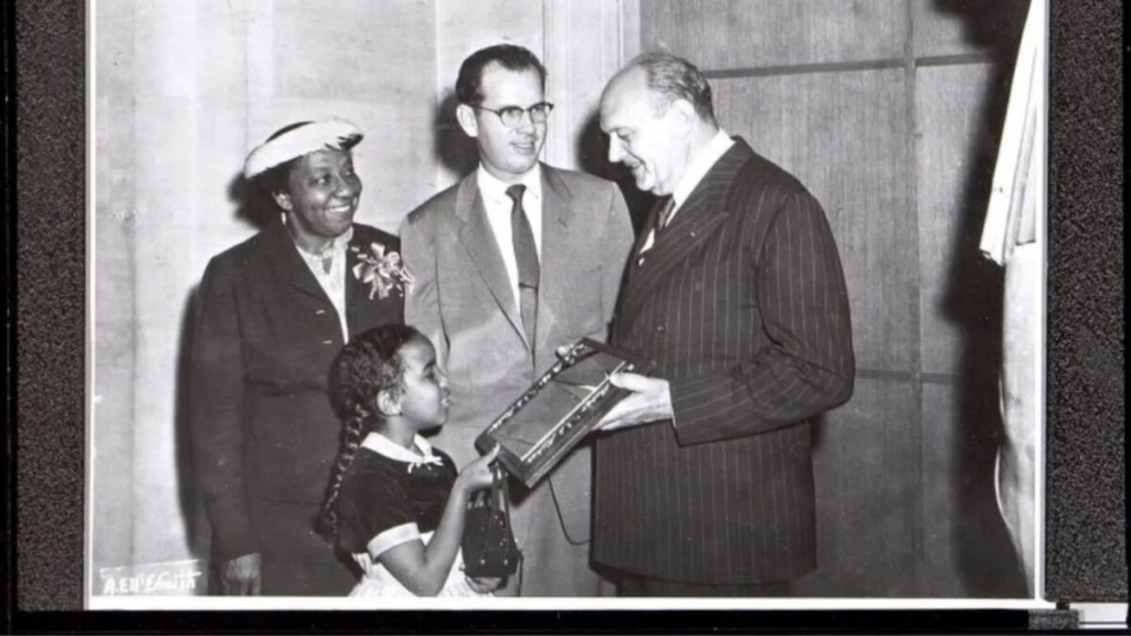 Photo credit: A.E. McSmith A young girl presents a civic award at a Los Angeles ceremony, c. 1950s. LA had the fastest-growing Black middle-class population of any western US city in that decade.