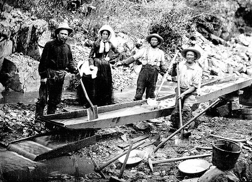 Gold prospectors work a sluice during the California Gold Rush. As many as 300,000 people flooded west after gold was discovered in 1848, and Bowman opened her first hotel to serve them.