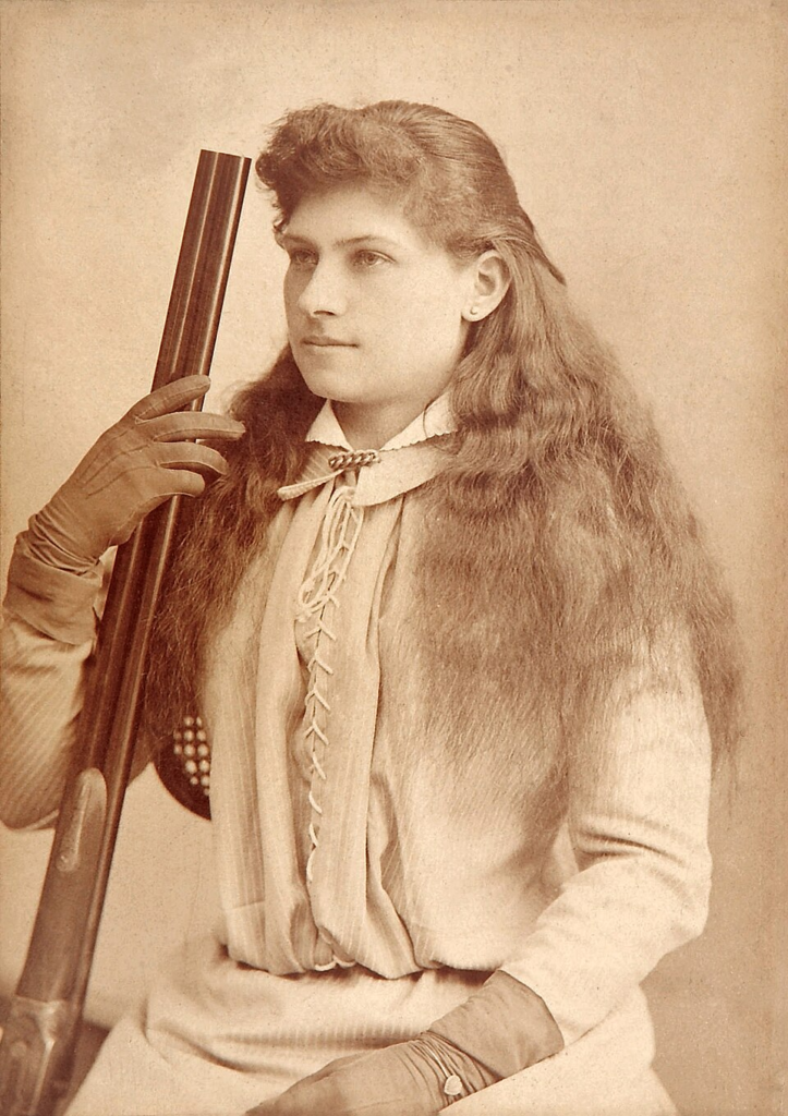 Annie Oakley poses with her rifle in this early portrait, taken during her rise to fame as the star sharpshooter of Buffalo Bill's Wild West show.